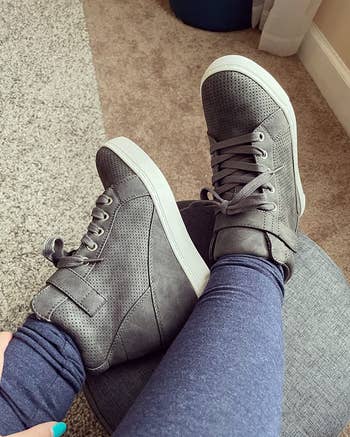 Person wearing perforated high-top sneakers 

