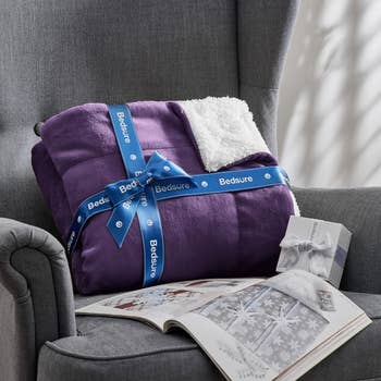 Bedsure branded throw blanket on armchair beside a magazine, ribbon wrapped for presentation