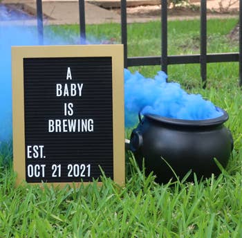 reviewer's baby announcement with cauldron full of smoke beside a baby is brewing sign 
