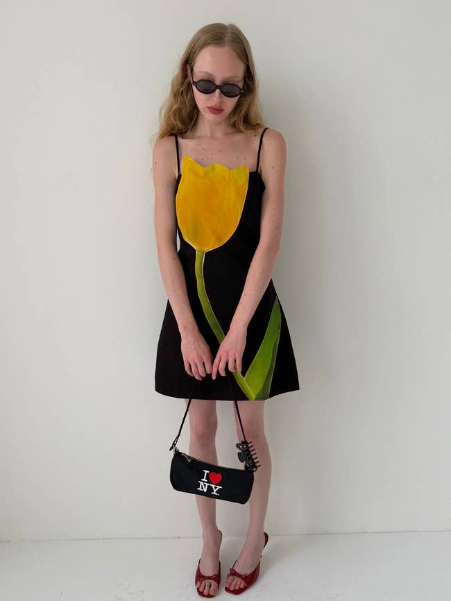 Person wearing a formal  with a tulip design, holding an 