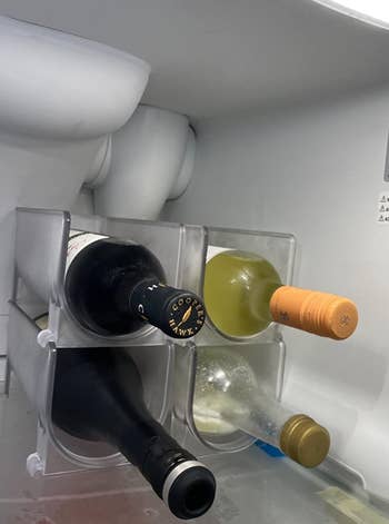 two of the wine racks set up side by side in a fridge holding wine