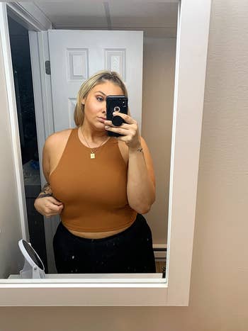 reviewer in same crop top in a dark yellow color