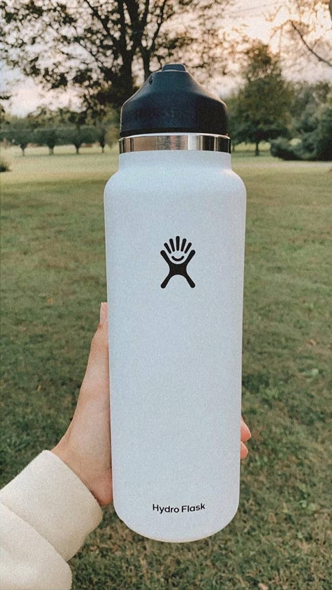 reviewer holding their white Hydro Flask water bottle