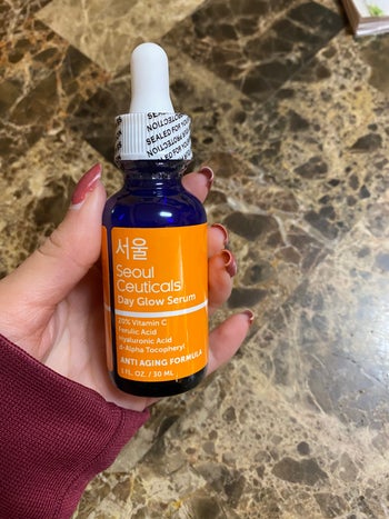 reviewer holding the bottle of serum