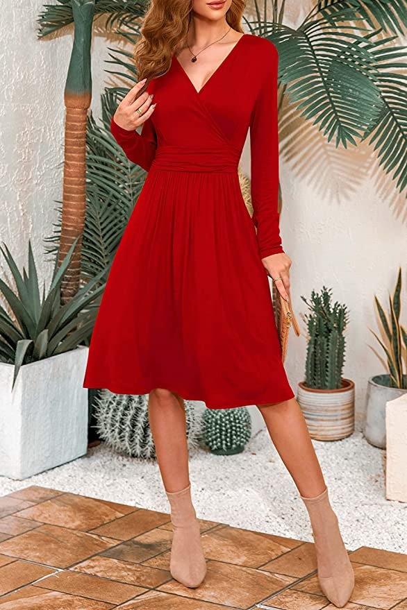 Model is wearing a bright red V-neck long sleeve dress with tan boots