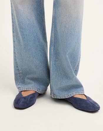 Wide-leg jeans paired with pointed-toe suede flats