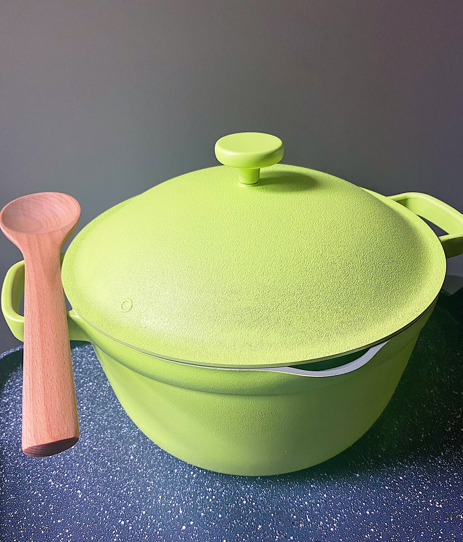 the bright green pot with a wooden spoon resting on its handle