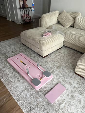 Foldable pinkish  pilates reformer acceptable   up   successful  a surviving  country   with a textured rug and beige sectional sofa