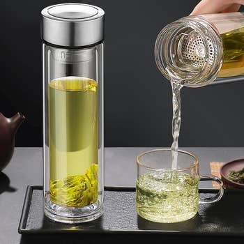 a  model pouring tea from the bottle with the strainer so none of the leaves go in the cup
