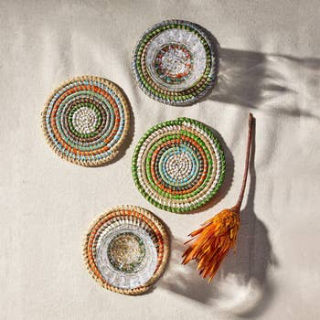 Four decorative coasters with a dried flower bouquet on the right