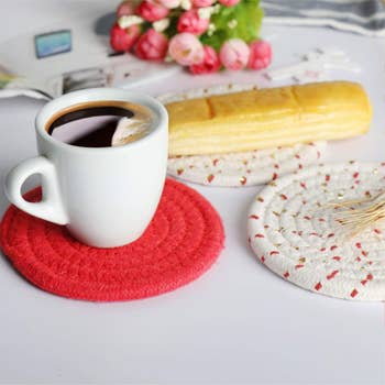a coffee mug and pastry on red and white coasters