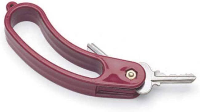 A red handle attached to the heads of two small keys 