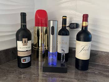 A reviewer's electric bottle opener with bottles of wine