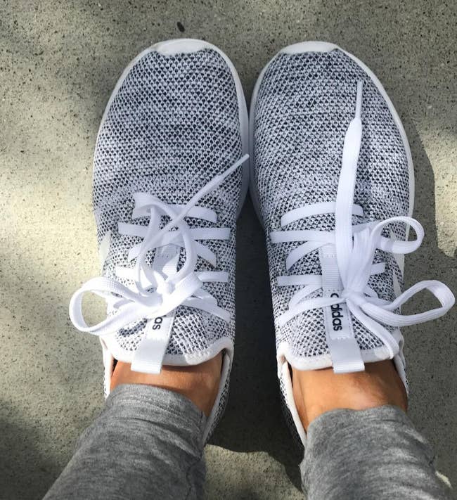 reviewer wearing the gray sneakers