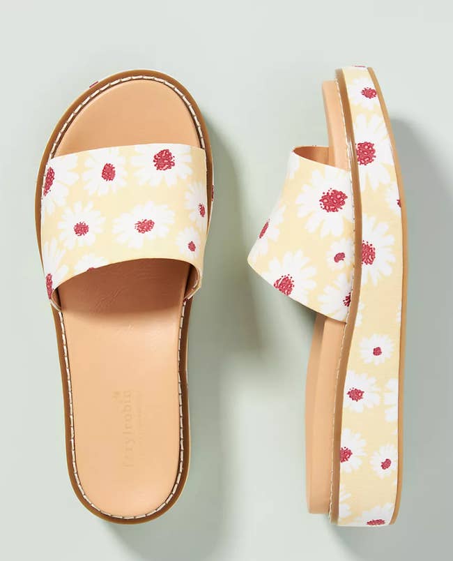 platform slide sandals in yellow with white daisies printed on them