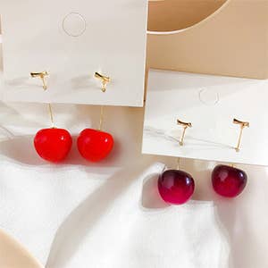 one lighter colored and one darker colored pair of cherry earrings