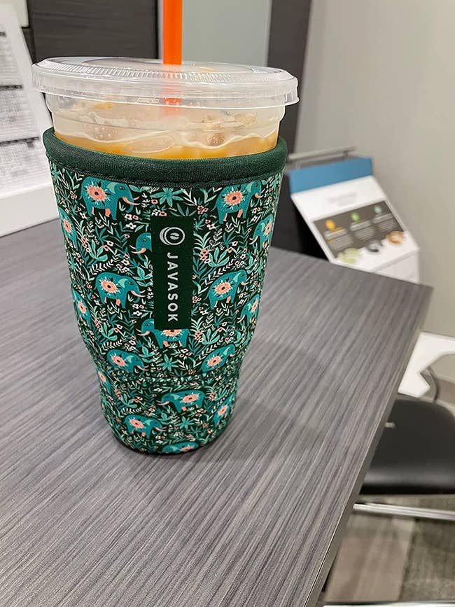 A reviewer's iced coffee in an insulator sleeve