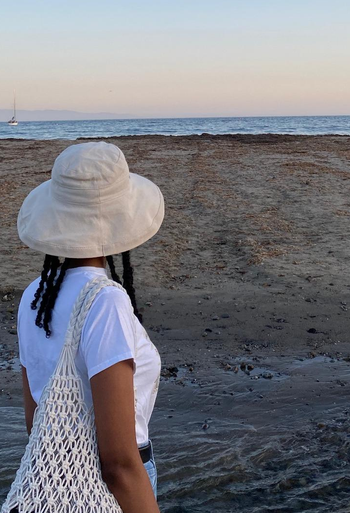 reviewer with the cream bag over their shoulder