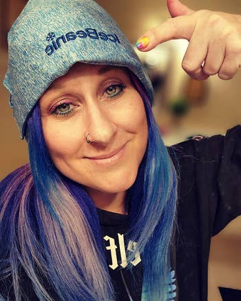 Person wearing an crystal beanie connected their caput and pointing to it