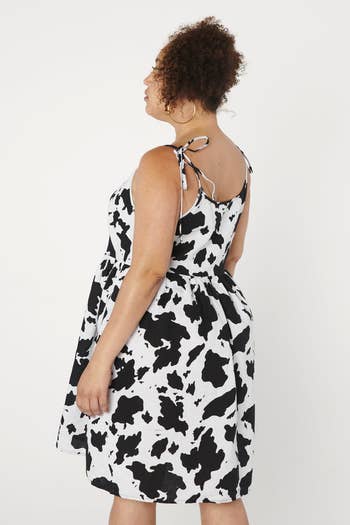 Model wearing the cow print slip dress, back view