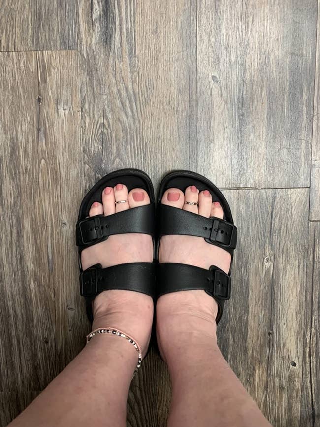 reviewer wearing the black sandals with two straps