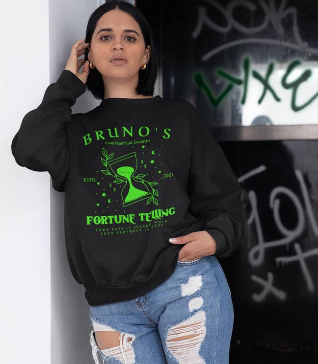 a model wearing the sweatshirt in black with green print