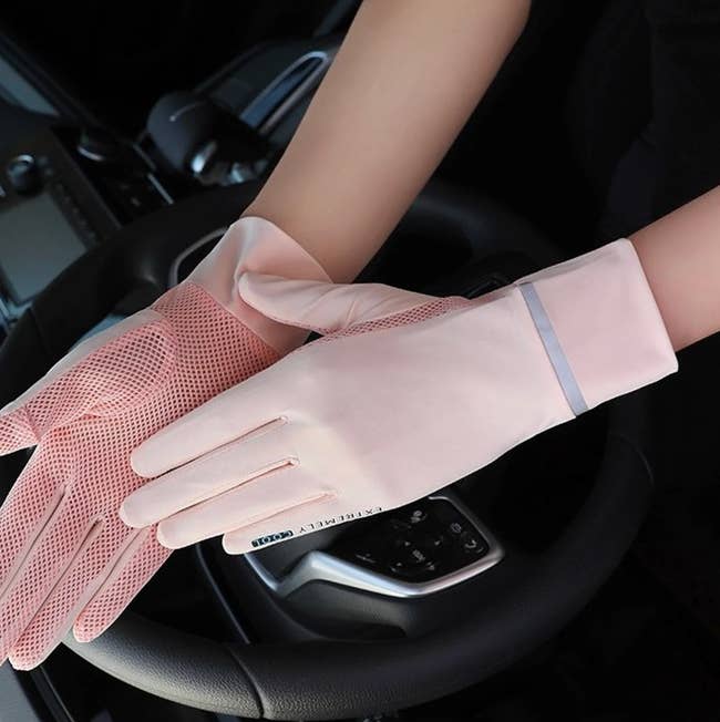 Model wearing light pink opaque gloves with mesh on the inner hand 