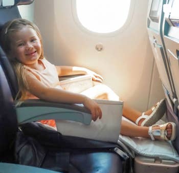 A child using the carry-on as a foot rest