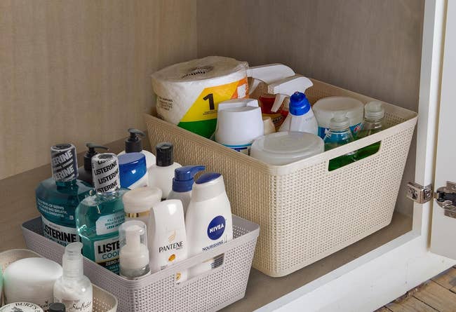 Assorted personal care products organized in storage containers inside a cabinet
