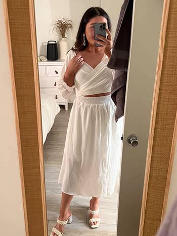 reviewer wearing the white dress with the crossover design in front
