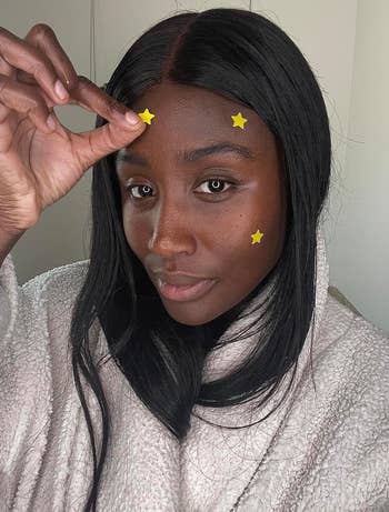 reviewer with several yellow pimple patches on their face