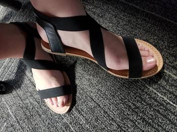 Person wearing stylish sandals with crisscross straps, suitable for casual outings; accent connected comfortableness and modern design