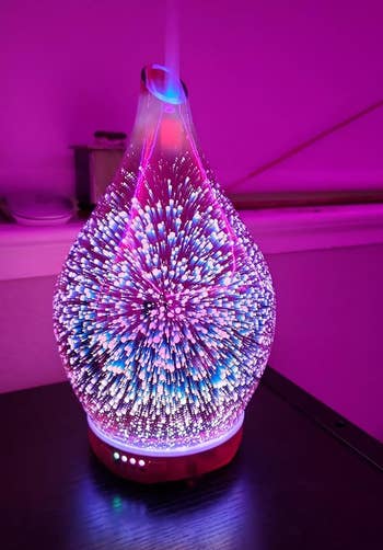 the essential oil diffuser glowing blue and pink