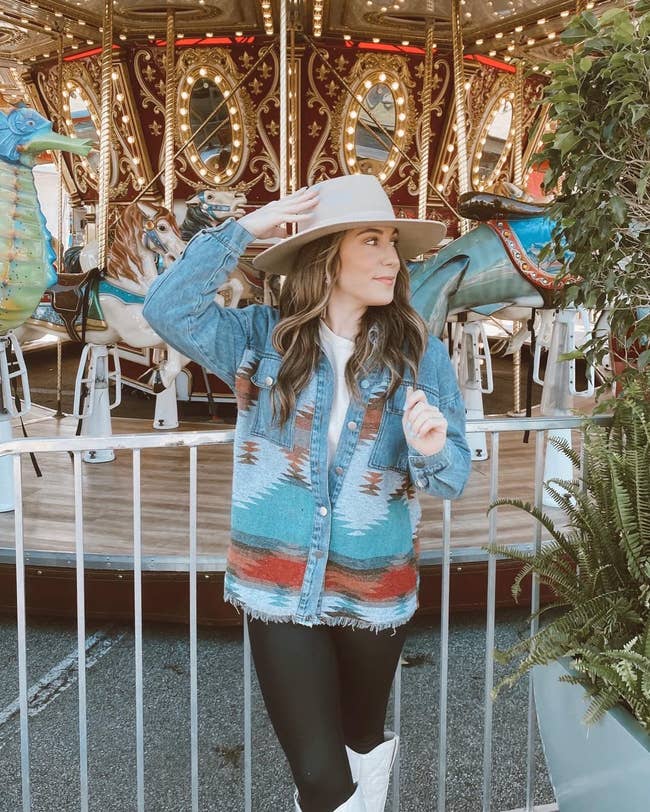 reviewer wearing geometric design denim shacket in front of merry-go-round
