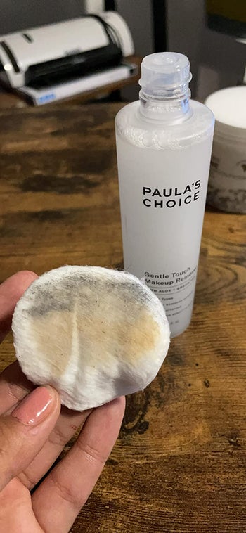 reviewer photo of the makeup remover next to used cotton pad