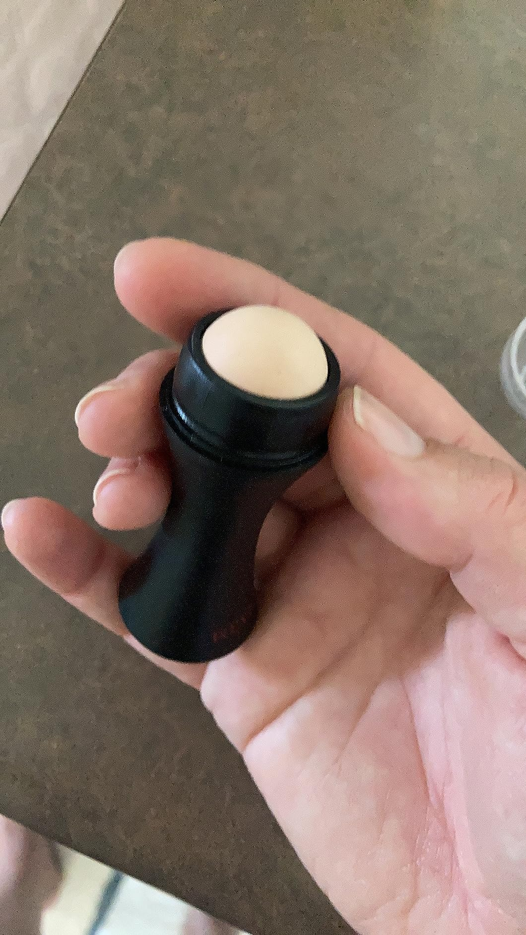 Person holding a small, circular  articulator  balm successful  a achromatic  tube, featured successful  a buying  article