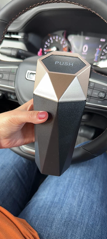 reviewer holding car trash can