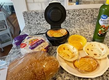 Reviewer using the cooker to make tortilla and waffle bowls 