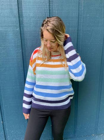 a reviewer in the striped rainbow sweater
