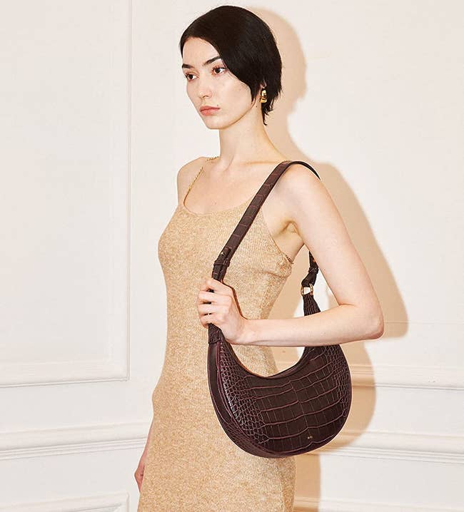 model wearing brown faux croc leather purse on their shoulder
