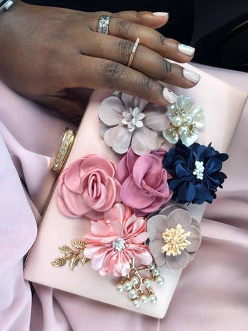 close up view of the clutch's textured flowers and gold embellishments