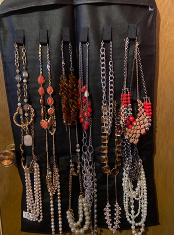 reviewer photo of organizer neatly holding various necklaces