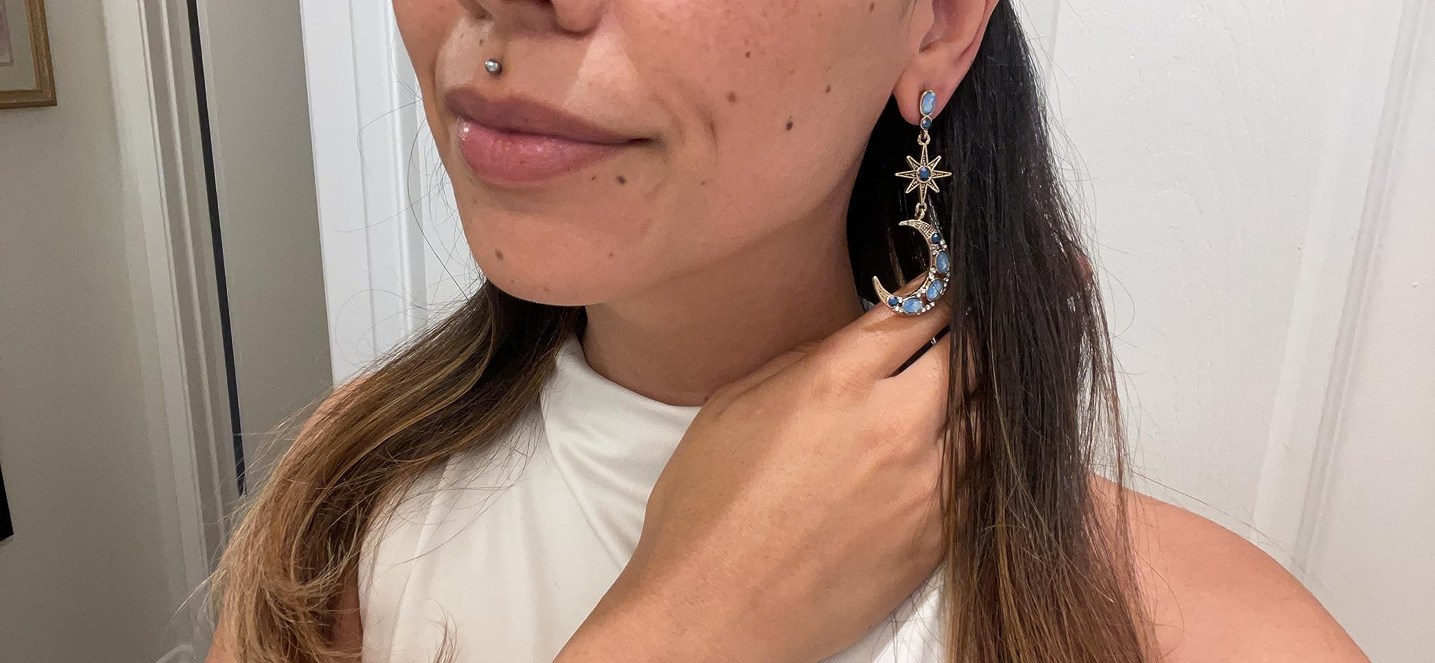 Reviewer wearing crescent satellite  and star-themed earrings
