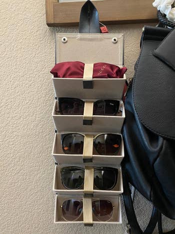 sunglasses storage case unlatched and hanging on a hook