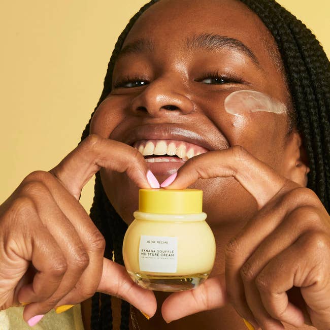 model holding a bottle of yellow cream