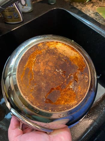 reviewer's before photo of bottom of a burned and stained stainless steel pan