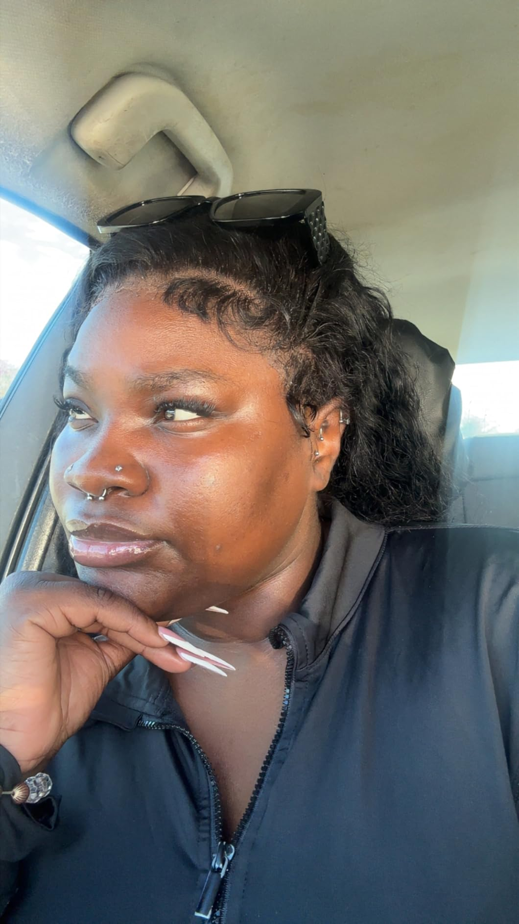reviewer with agelong  nails and sunglasses connected  head, sitting successful  a car, resting manus  connected  chin, looking thoughtful
