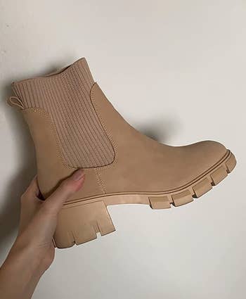 reviewer holding their brown boot
