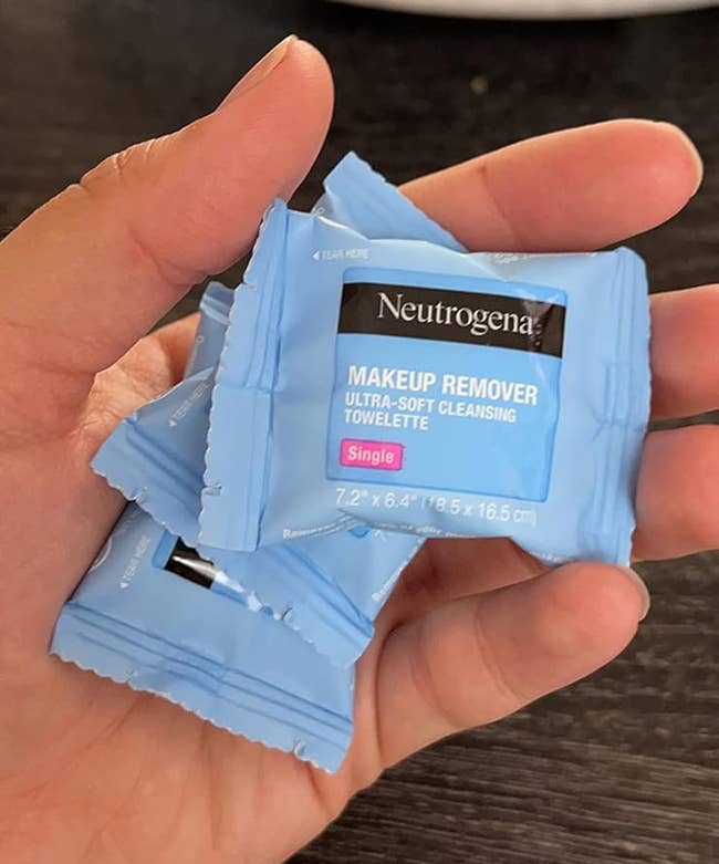 Reviewer holding individually wrapped towelettes