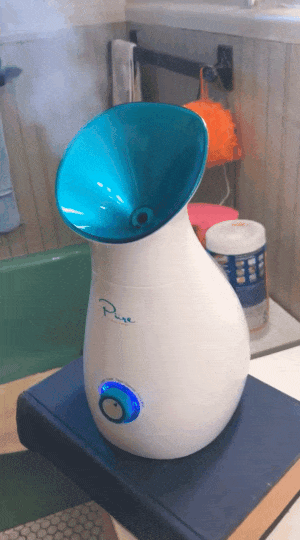 gif of reviewer's facial steamer on and blowing steam